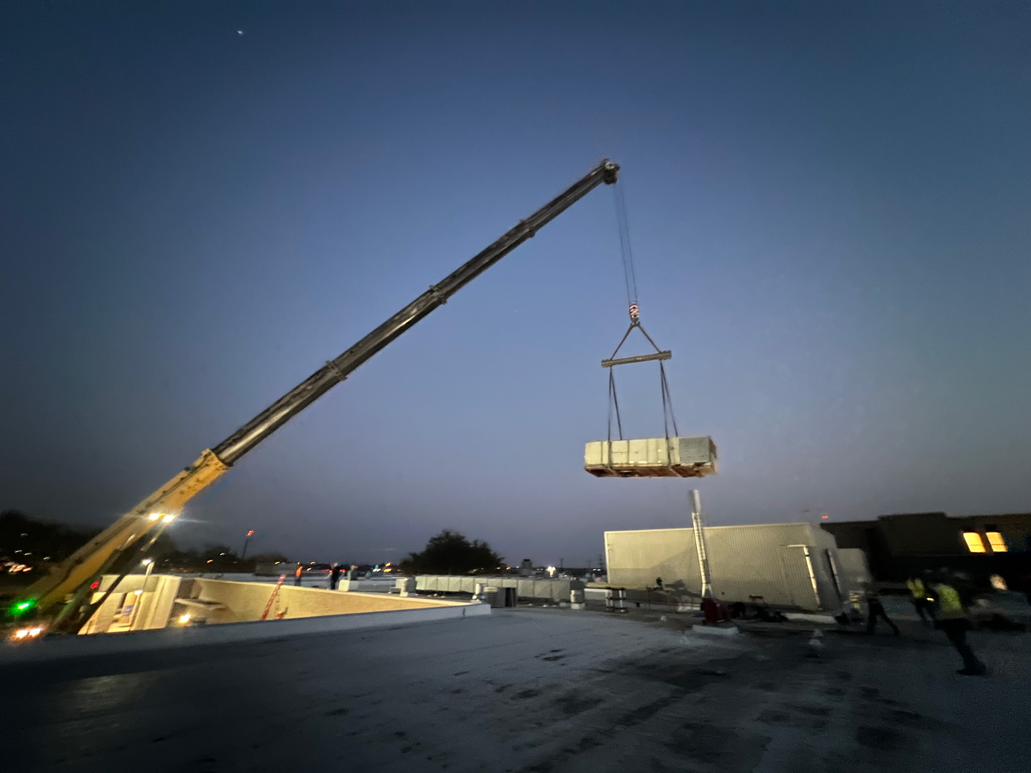 Lifting a unit on a rooftop.